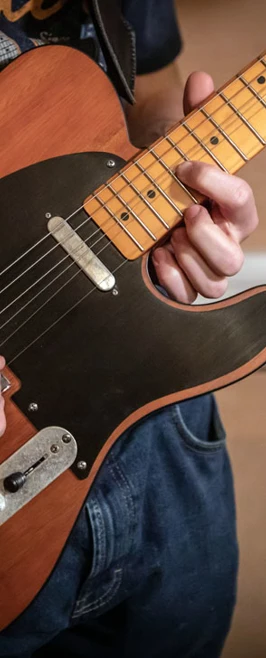 A close-up of a musician’s hands playing an electric guitar. A close-up of a musician’s hands playing an electric guitar.